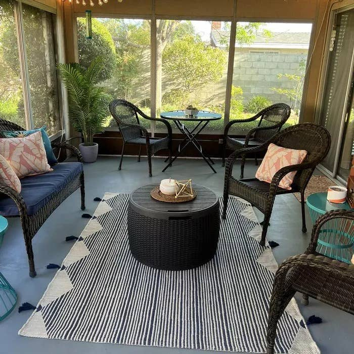 Outdoor patio area rug with navy-and-ivory global linear stripe pattern and tassel border