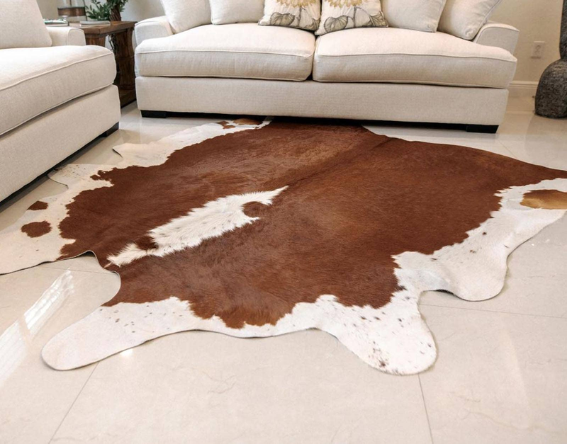 Brown and white cowhide area rug under a sofa in a living room