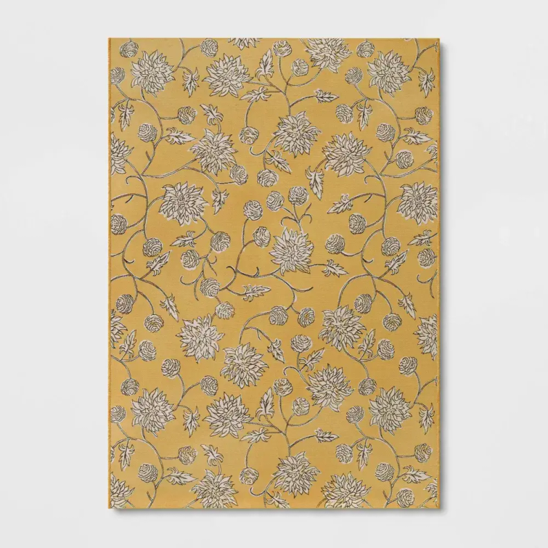 Yellow area rug with all-over white floral outlines and small dark accent details