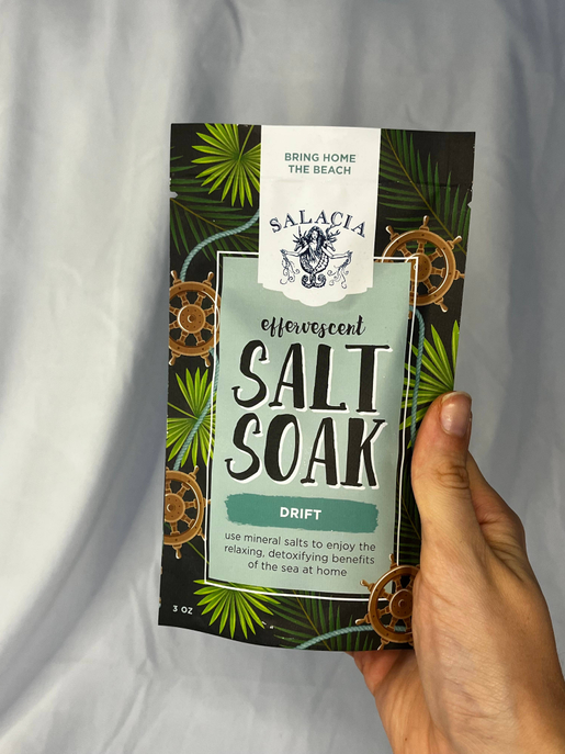 Effervescent Salt Soak packet held in hand, Drift with green tropical label