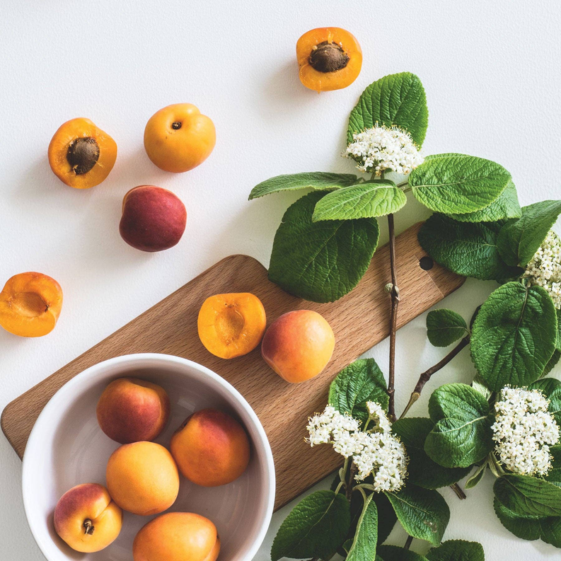 Georgia Peach scrub ingredients: bowl of peaches with green leaves