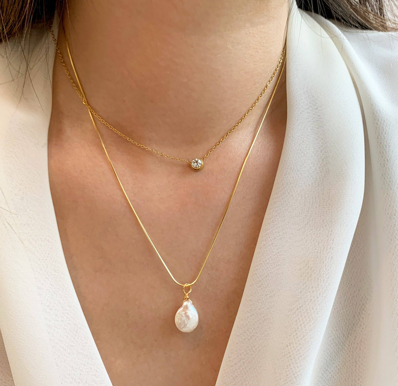 Layered gold-tone necklace set with teardrop pearl drops and small round crystal accents