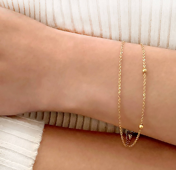 Gold-tone double chain bracelet with small heart charm and bead links