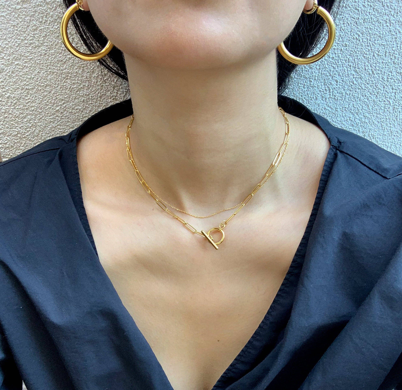 Gold paperclip chain necklace with round toggle centerpiece and bar charm