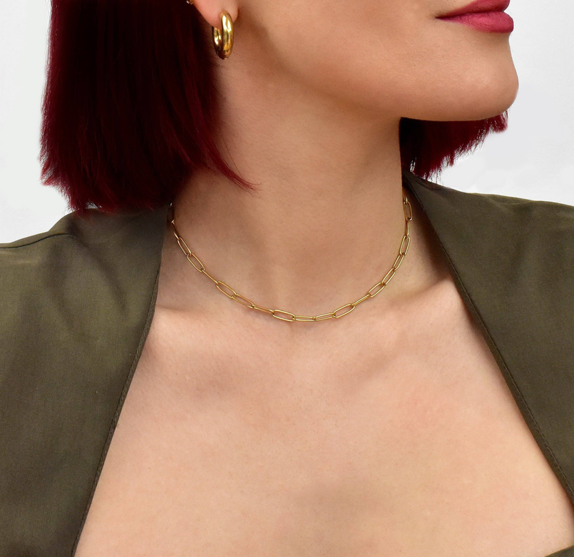 Gold paperclip chain necklace on neckline with interlocking oval links