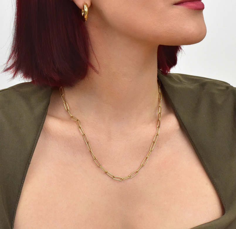 Gold paperclip chain necklace with smooth oval links resting at collarbone