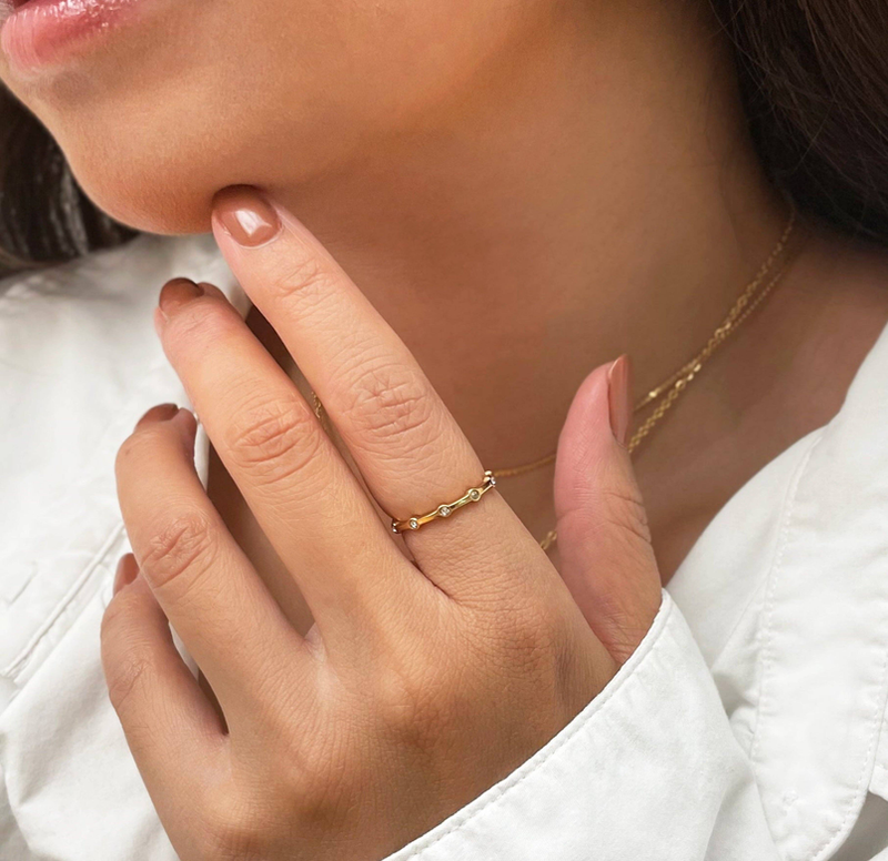 Gold-tone thin pave ring on finger with small round stones