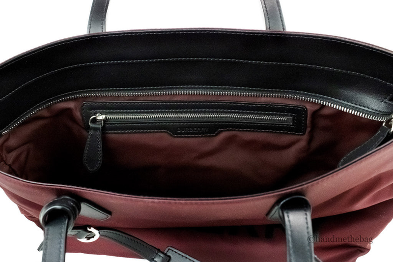 Burgundy nylon tote interior with zippered pocket and black top zipper trim
