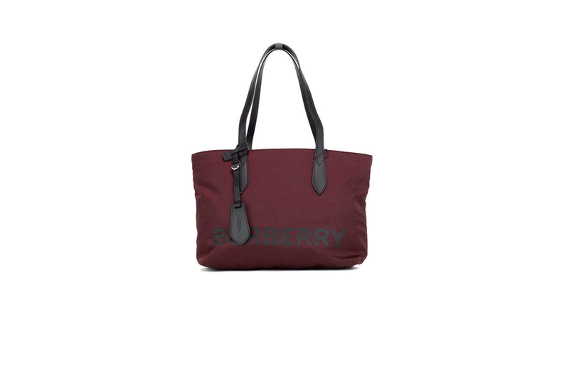 Burgundy nylon tote bag with black top handles and subtle front logo lettering