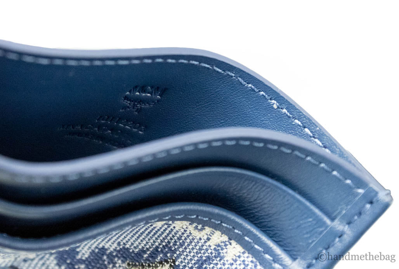 Blue leather card case corner detail with contrast stitching and embossed logo
