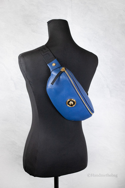 Blue leather fanny pack on mannequin with adjustable strap and gold Medusa detail
