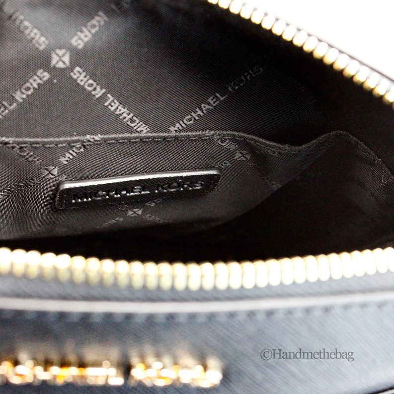 Open black crossbody bag interior with logo patch and gold zipper hardware