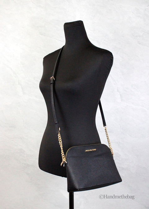 Black dome crossbody bag on mannequin with gold-tone chain strap and zipper pocket