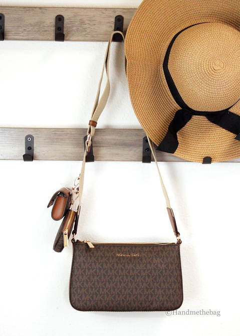 Brown monogram crossbody bag with adjustable strap and zipped front pocket