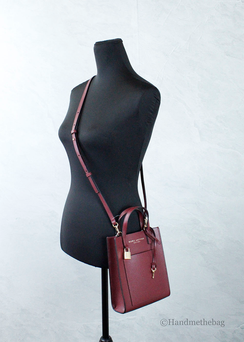 Pomegranate red leather micro mini crossbody bag with adjustable strap on mannequin
