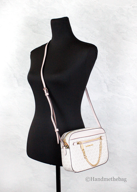 Michael Kors crossbody bag on mannequin: white MK monogram with pink strap and zip top