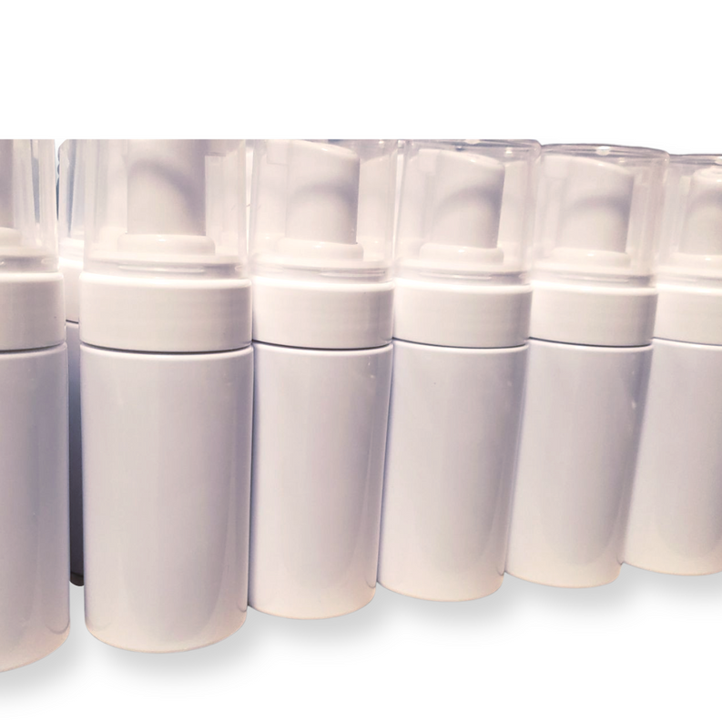 Close-up of white foaming wash bottles with white caps lined in rows