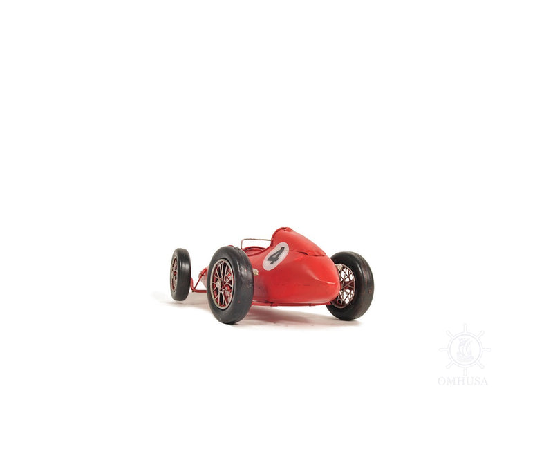 Red metal model car tabletop sculpture with black tires and front badge, angled view