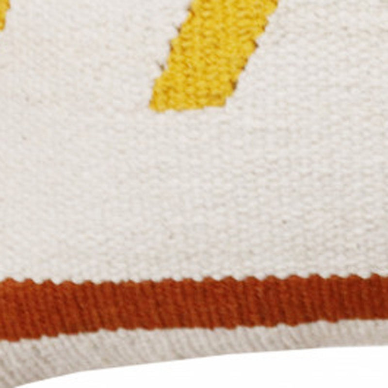 Close-up of textured cotton chevron pillow fabric: white weave, yellow stitch pattern, rust band