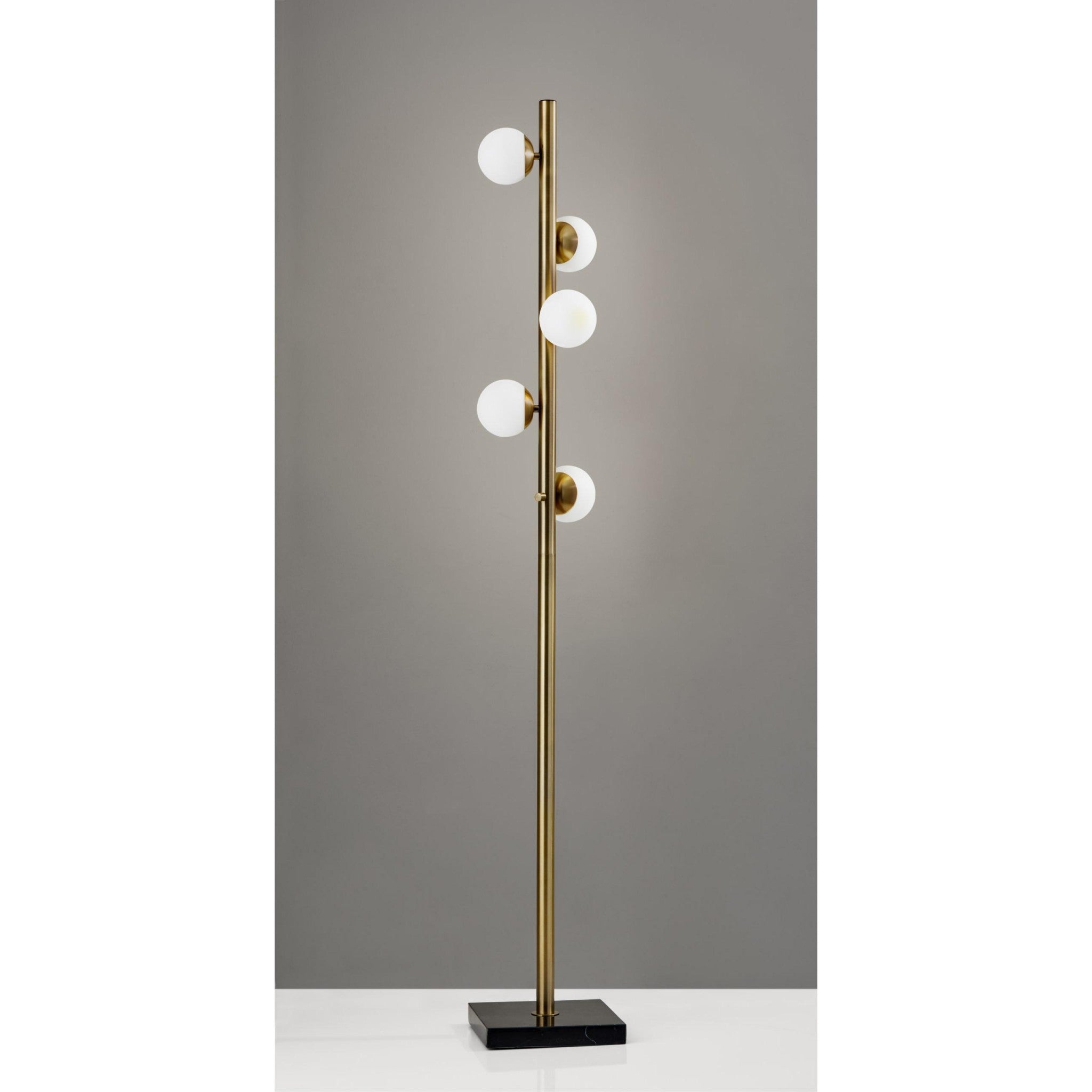 Modern brass floor lamp with five white globe shades on a black base, perfect for contemporary home decor.