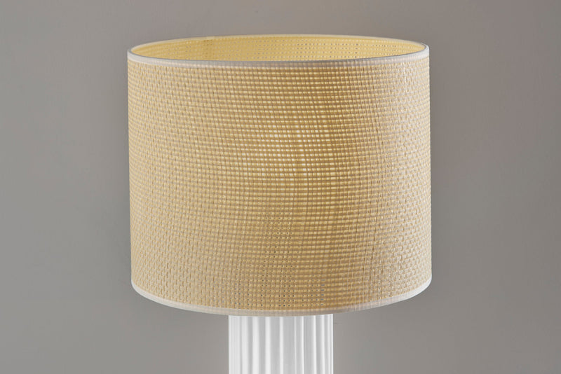 Table lamp with beige drum shade and white ribbed cylinder base.