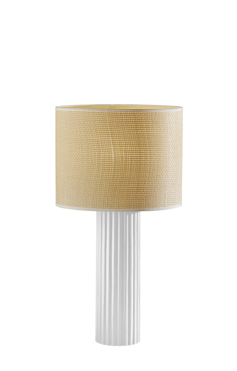 Table lamp with beige drum shade and white fluted cylinder pedestal base.