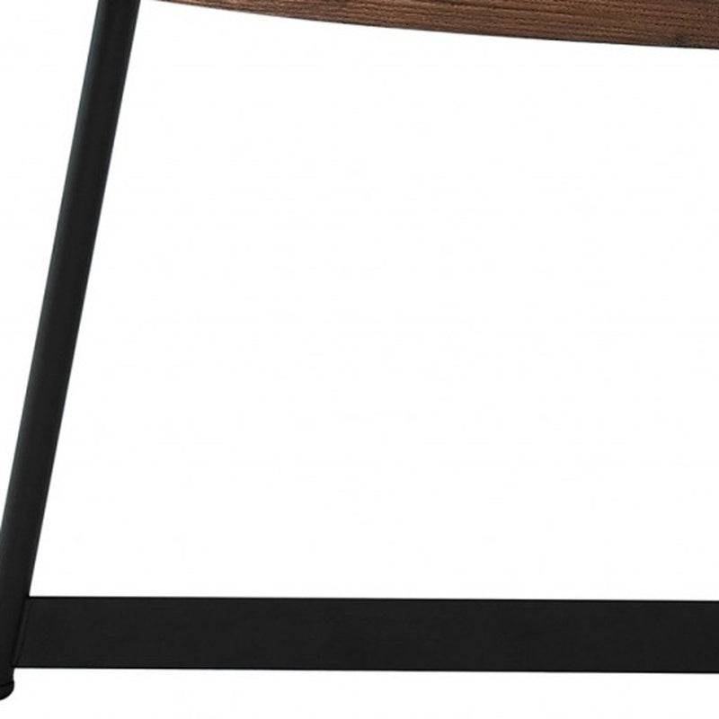 Black metal table leg and brown wood edge of an oval coffee table