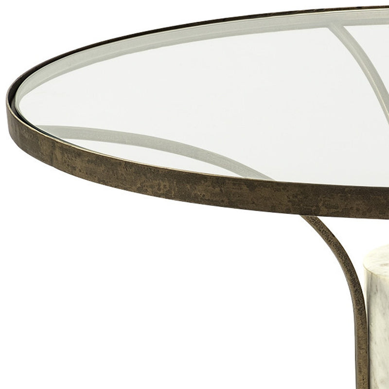Close-up of round glass tabletop edge with antiqued gold iron trim and marble pedestal