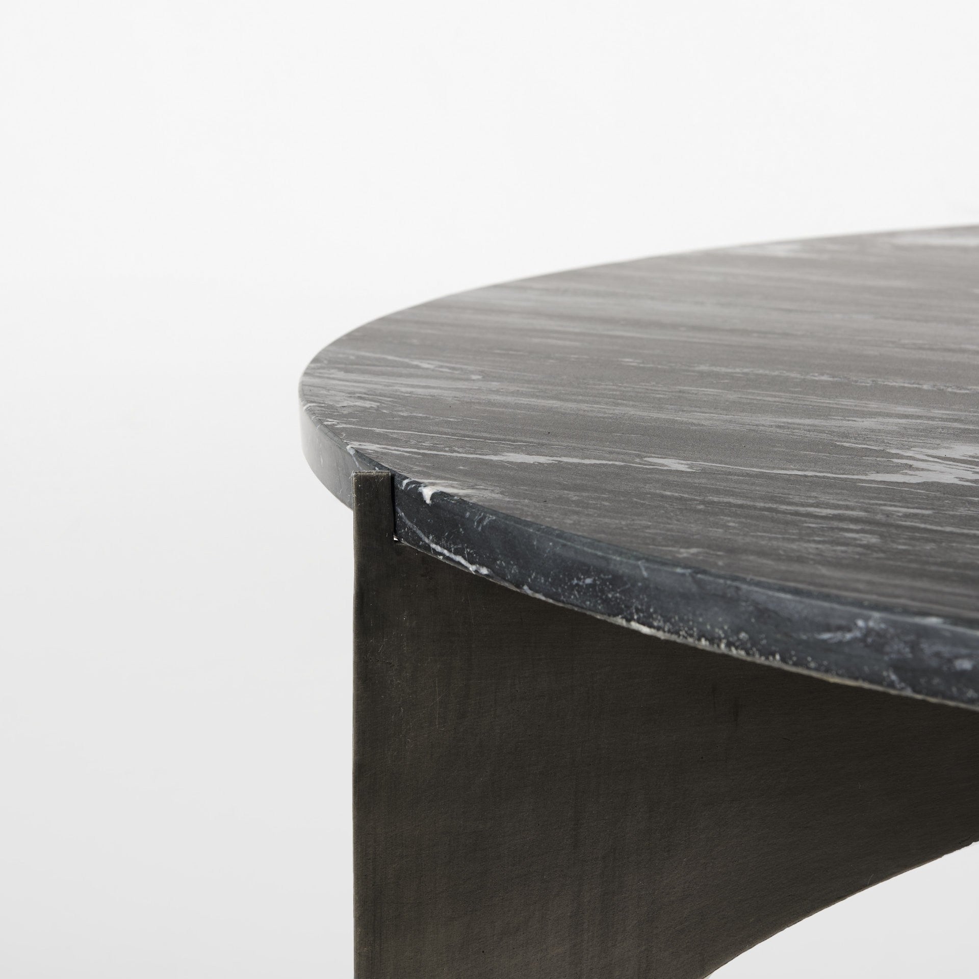 Black round marble coffee table corner with dark iron side leg
