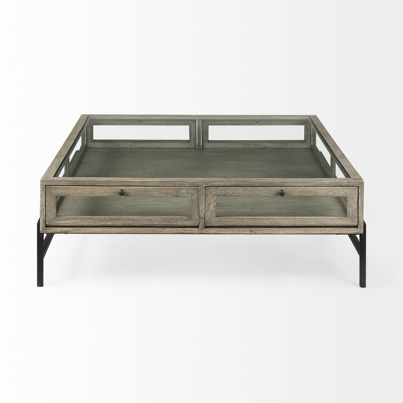 Square coffee table with gray wood-look cabinet drawer fronts, glass tabletop, black base