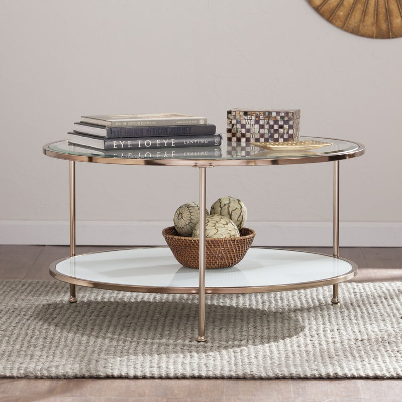Round clear glass coffee table with gold iron base and two glass shelves