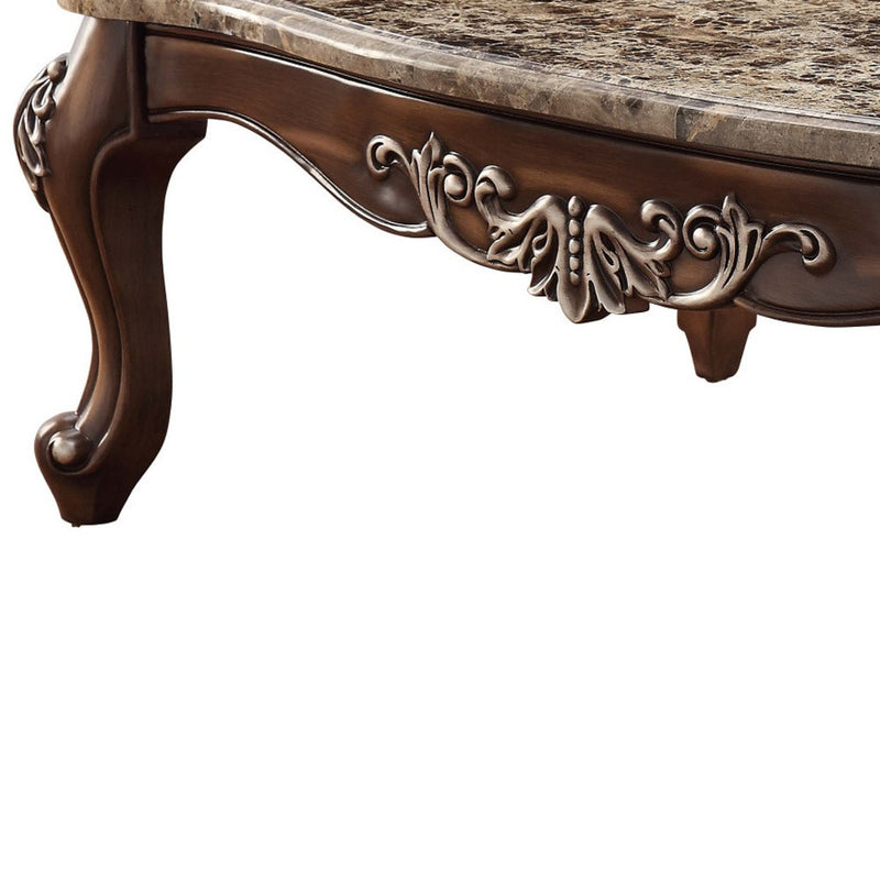 Brown coffee table leg and carved apron detail with faux marble tabletop