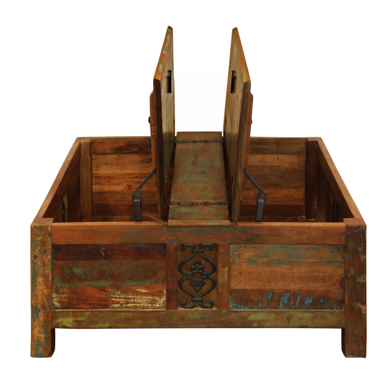 Brown trunk-style coffee table with open lift top, metal supports, and carved front