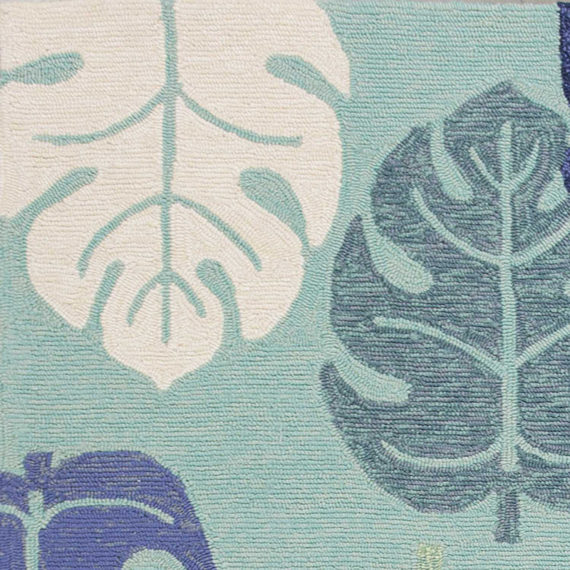 Turquoise leaf-pattern area rug with cream and blue botanical shapes