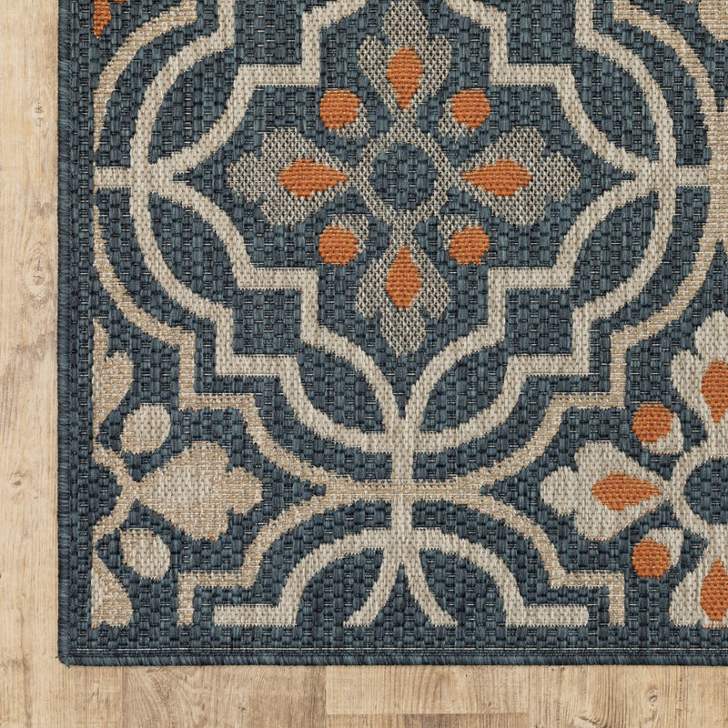 Close-up of Moroccan rug medallion pattern in blue and tan with orange accents