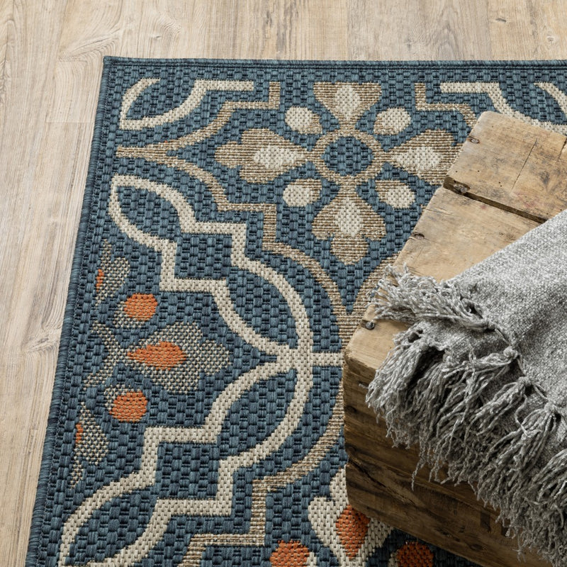 Teal-blue Moroccan rug with raised texture, orange spots, and cream geometric motifs