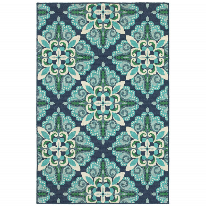 Indoor outdoor area rug flat view with navy background and repeating teal and cream florals
