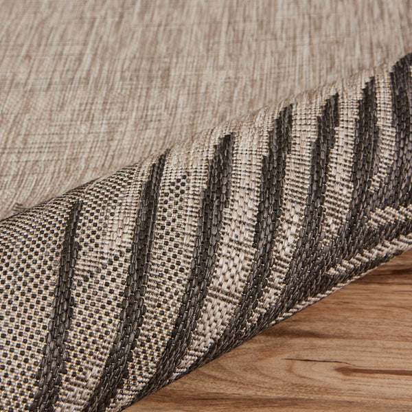 Beige and dark gray indoor/outdoor area rug with striped woven edge detail