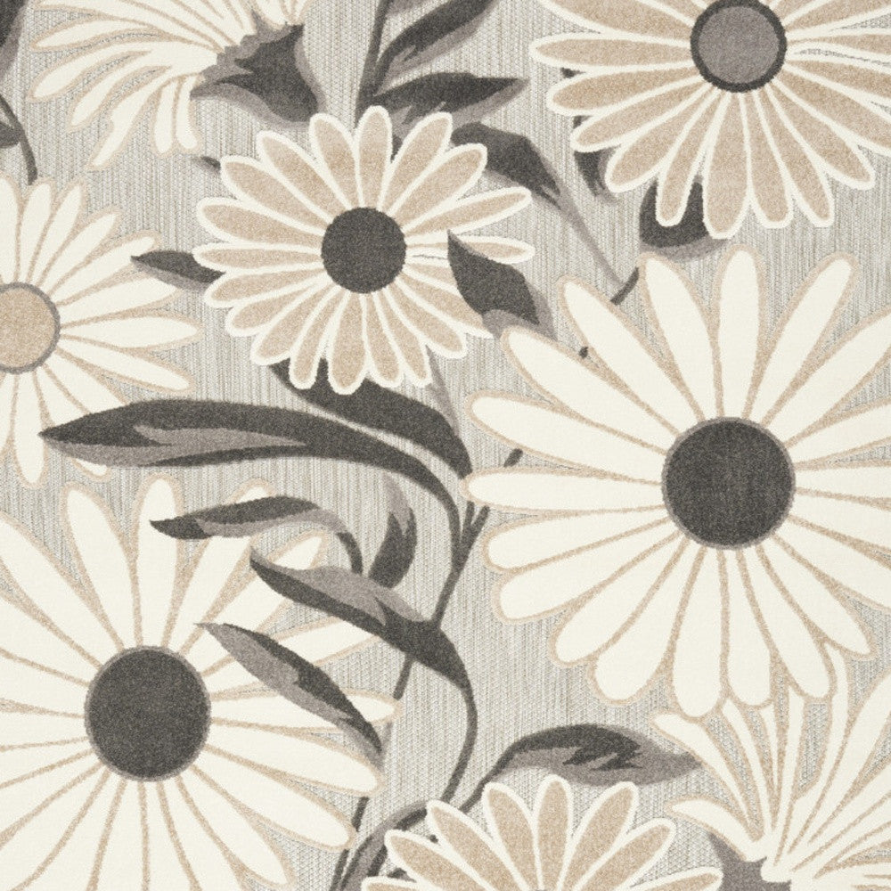Beige floral area rug close-up showing layered daisies and dark leaves
