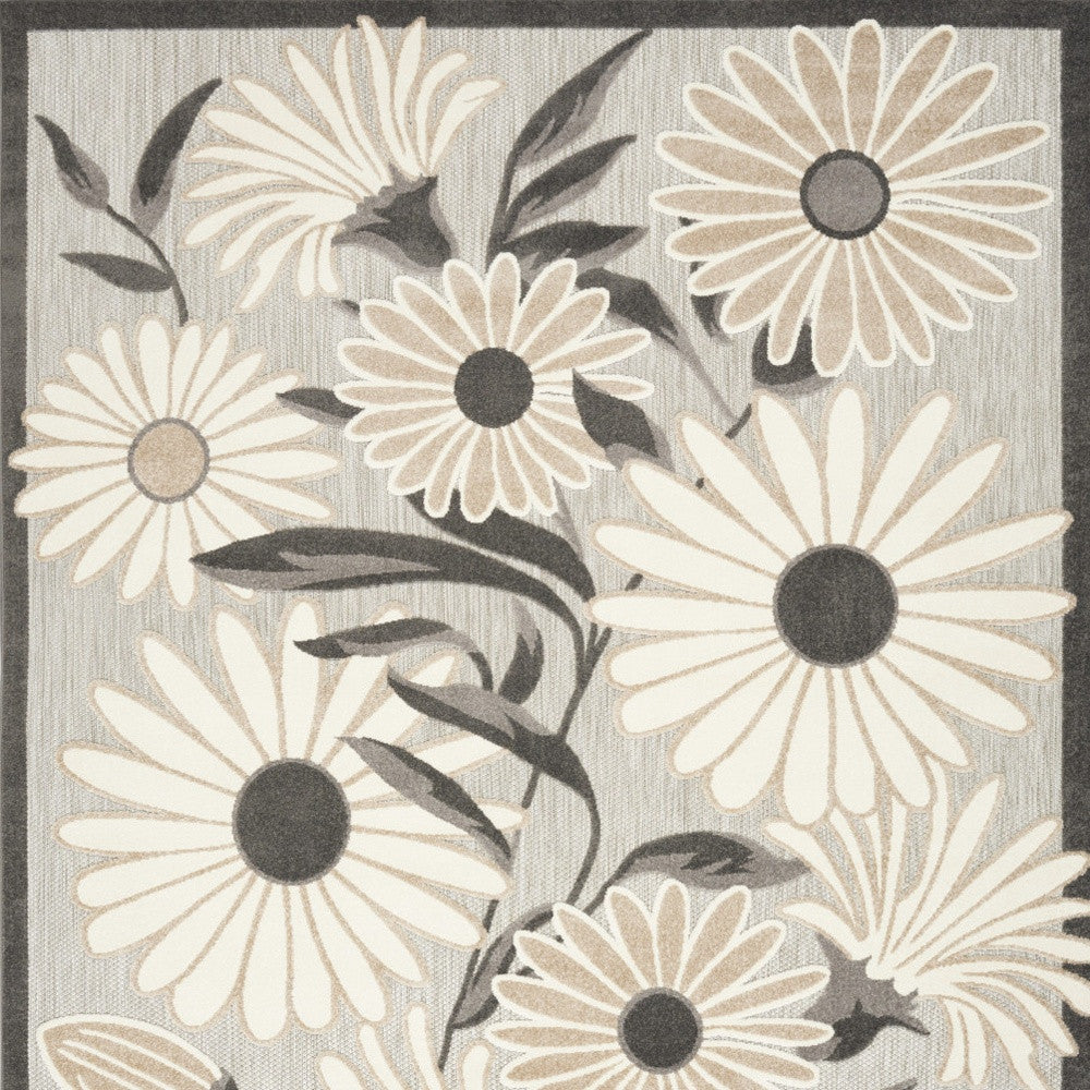 Beige and dark floral area rug close-up with daisy-style flowers and leaves