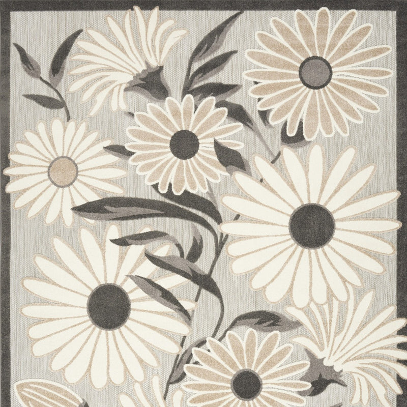 Beige and dark floral area rug close-up with daisy-style flowers and leaves