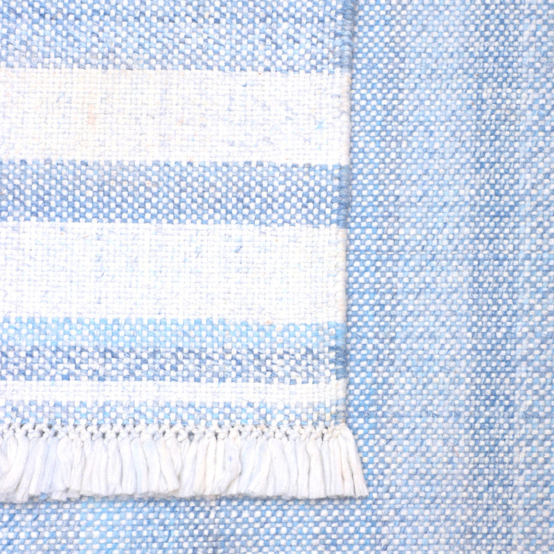 Close-up of rug fringe and woven stripes in light blue and white