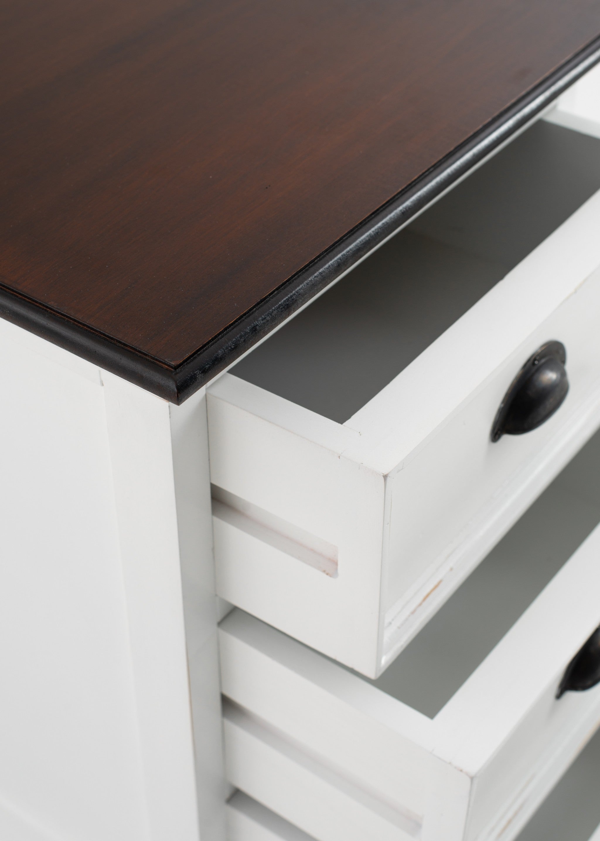 Side view of white 3-drawer nightstand with dark top edge and open drawer space