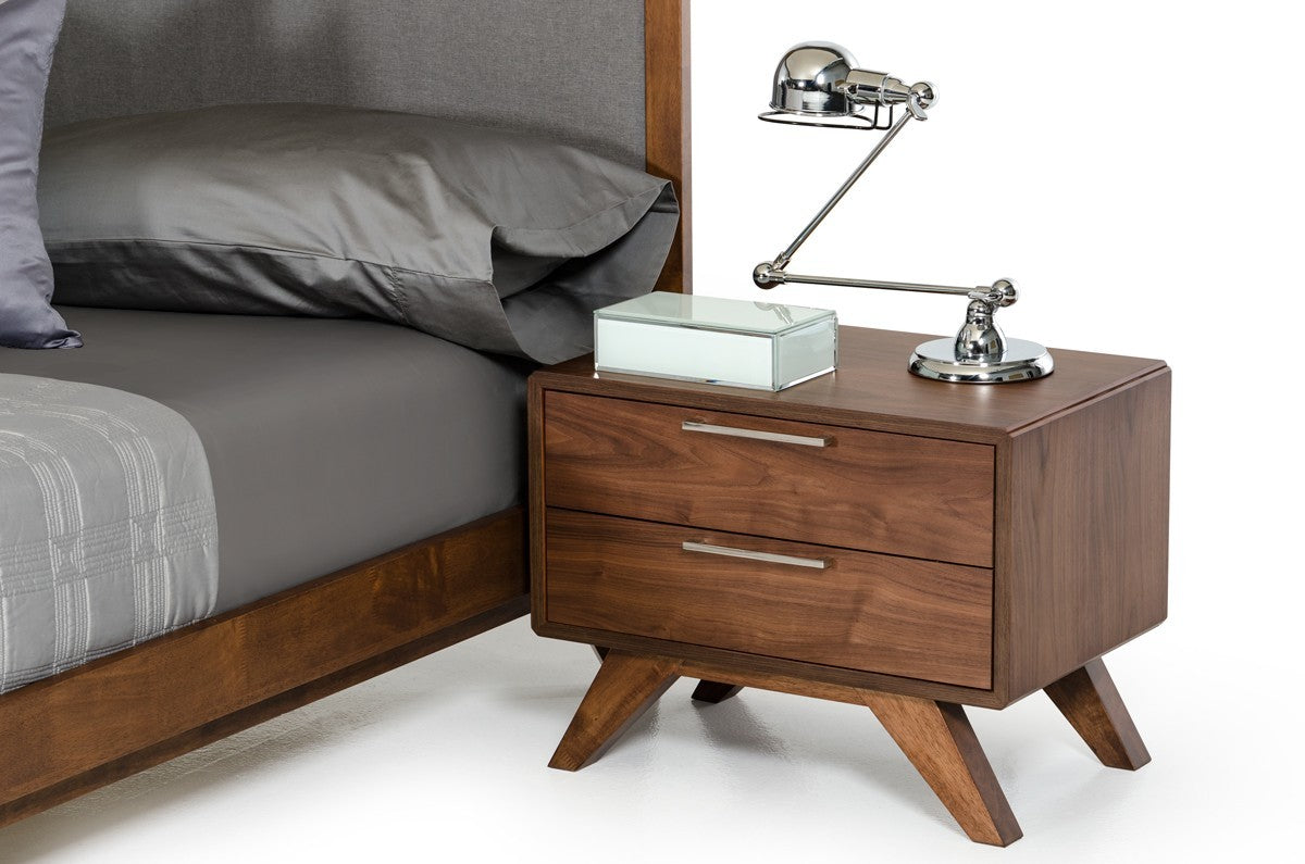 Walnut-toned two-drawer nightstand with silver pulls, styled as a bedside table