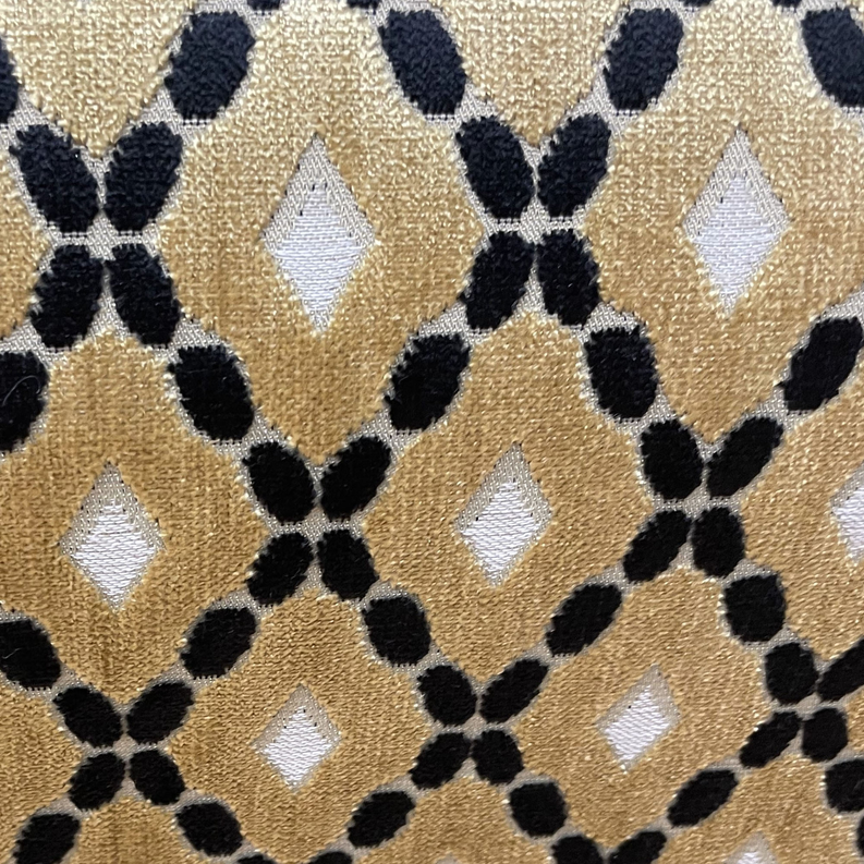 Gold velvet throw pillow fabric close-up, black interlocking diamond motif with light highlights