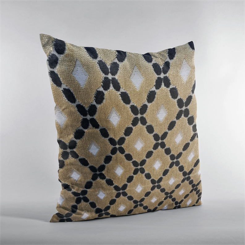 Square decorative pillow in cream-gold with black lattice and diamond motifs.