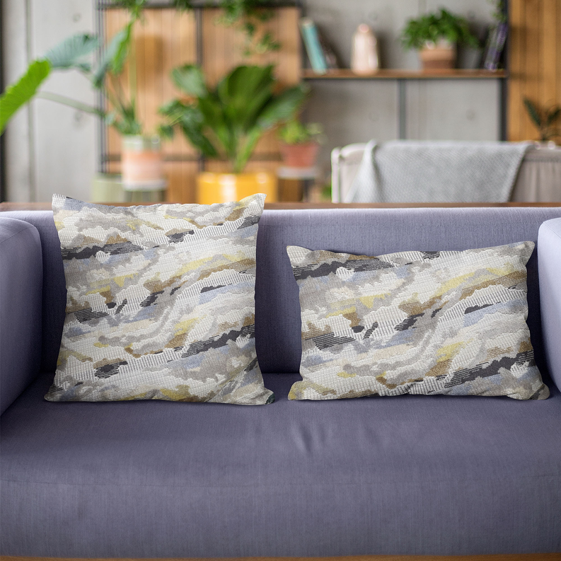 Handmade luxury throw pillow with abstract gray, black, and citrine pattern and fringe edges