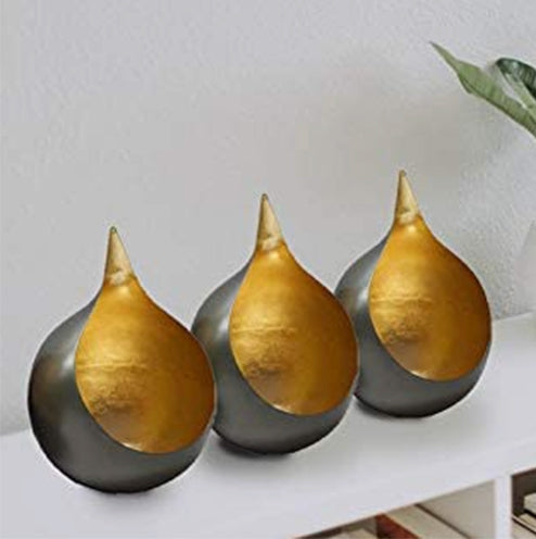 Three gold teardrop tea-light candle holders with dark outer bases