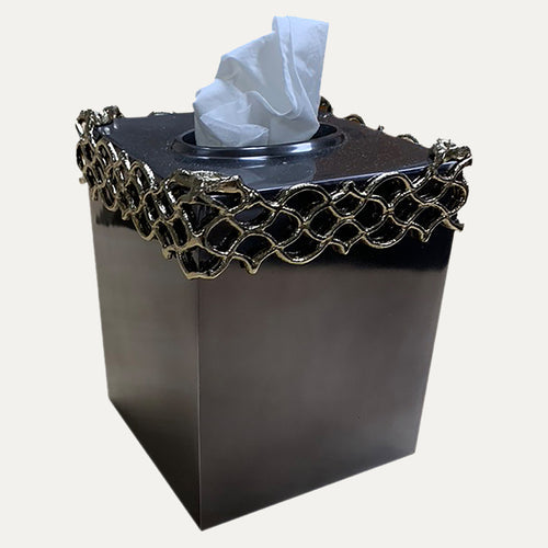 Tissue box cover, dark square with glossy black top and gold lattice band holding tissue.