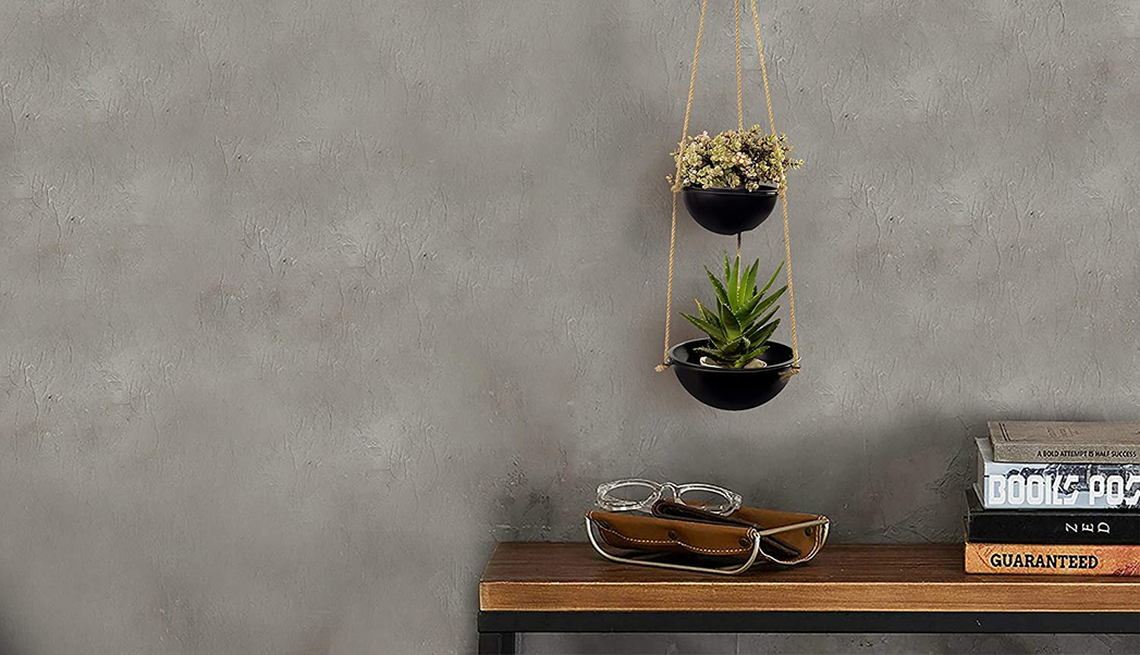 Two-tier hanging planter with two black pots suspended by rope, with flowers and succulent